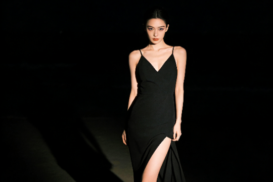 Elegant woman in black dress with thigh-high slit. Exclusive KL Escort.